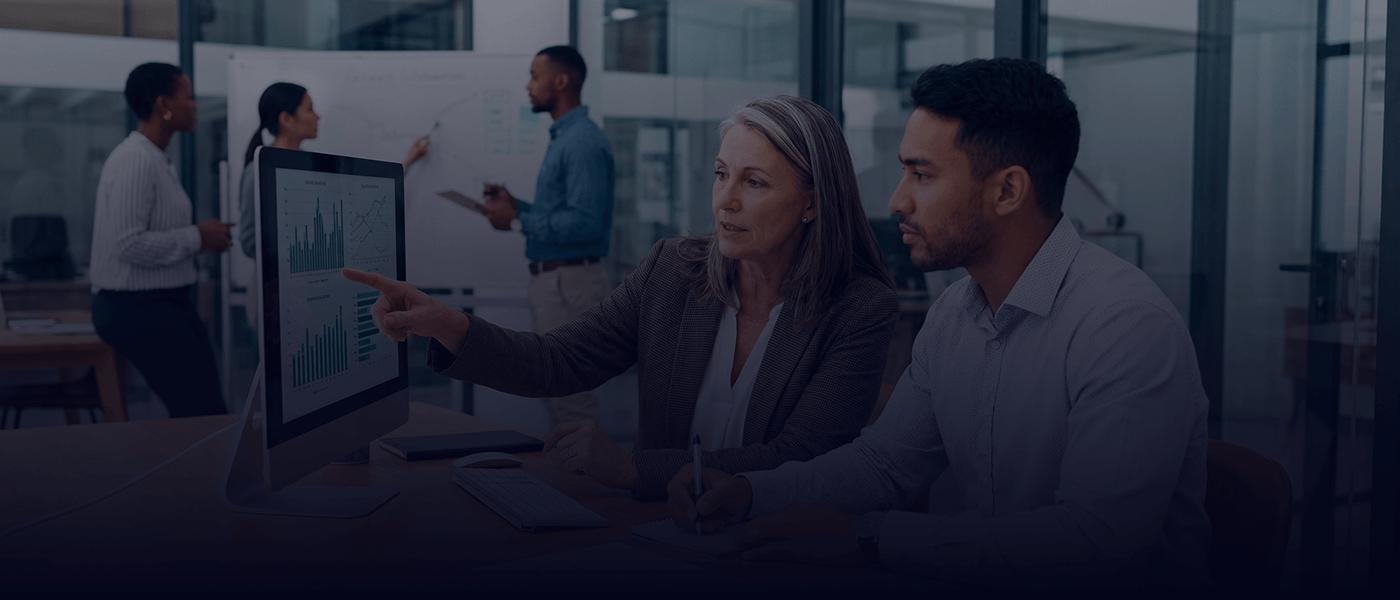 Séance de mentorat et analyse de données entre collègues dans un bureau moderne.